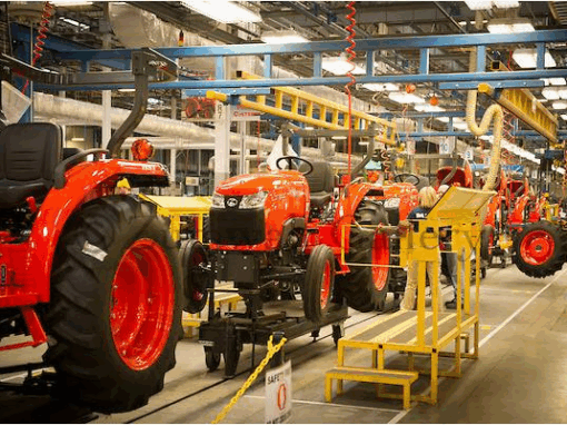 Kỹ sư Kubota đang tỉ mỉ kiểm tra chi tiết máy trong dây chuyền lắp ráp sáng bóng, hiện đại