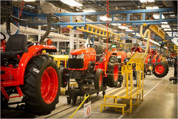 Kỹ sư Kubota đang tỉ mỉ kiểm tra chi tiết máy trong dây chuyền lắp ráp sáng bóng, hiện đại